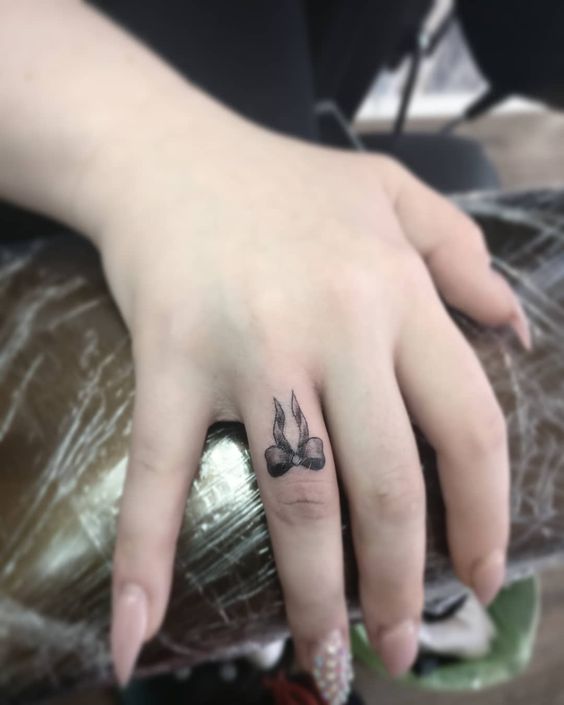 Delicate Bow Finger Tattoo
