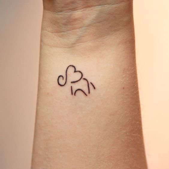 Little elephant and butterflies tattooed on the wrist.